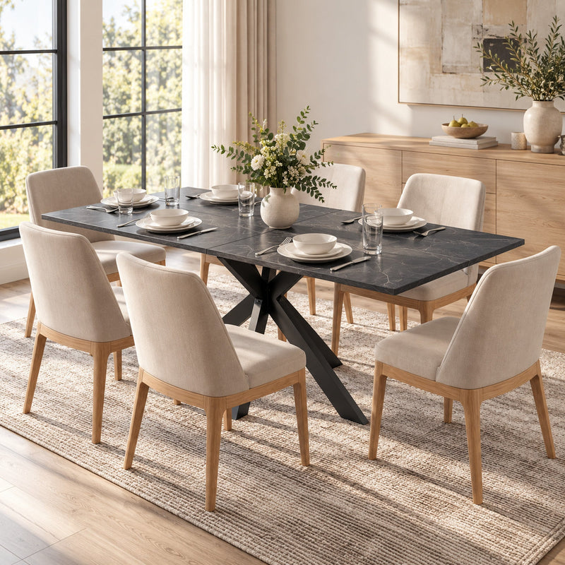 Black marble effect table with dishes and flowers surrounded by cream chairs