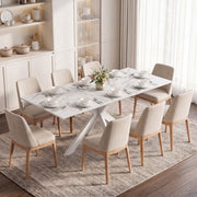 White marble effect extendable dining table laid for dinner with beige chairs