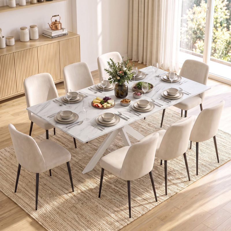 White marble effect table laid for a meal with cream chairs beside a sideboard