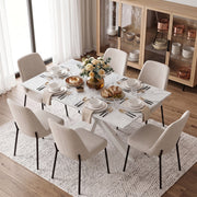 White marble effect table with dishes and flowers surrounded by cream chairs