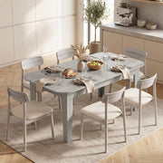 Dining table laid with plates and a bread basket, surrounded by 6 chairs