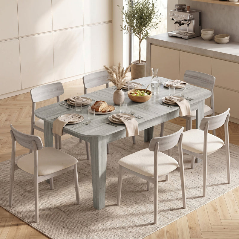 Dining table laid with plates and a bread basket, surrounded by 6 chairs