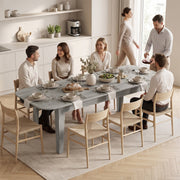 Family and friends gathered around the extended dining table in a kitchen