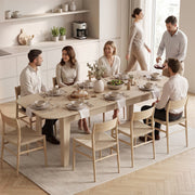 Group of adults sharing a meal at the fully extended table