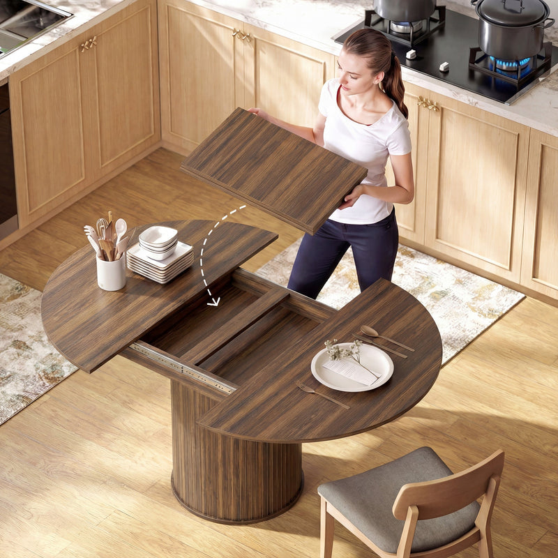 Woman lowering an extension board into the opened walnut table in a kitchen