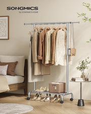 Songmics branded silver clothes rail styled in a bedroom with hanging clothes and shoes