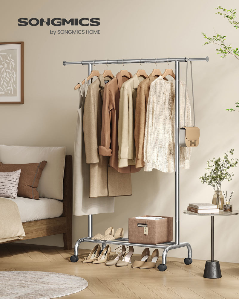 Songmics branded silver clothes rail styled in a bedroom with hanging clothes and shoes
