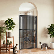 Black pet gate fitted in an arched doorway with plants, a toddler and cats