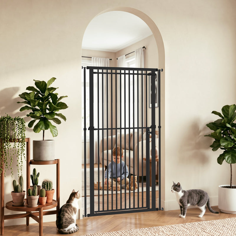Black pet gate fitted in an arched doorway with plants, a toddler and cats