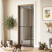 Black pet gate in a hallway doorway with two cats playing nearby