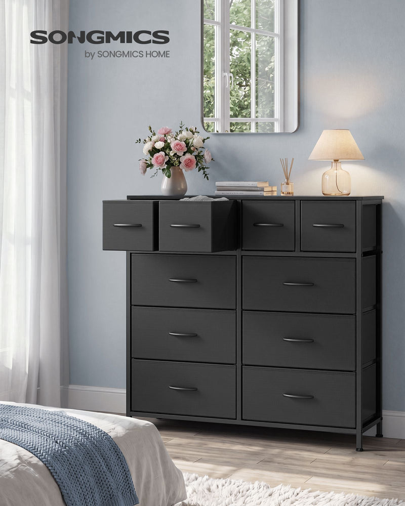 Ink black 10 drawer fabric chest in a bedroom with top drawers open beside a mirror and lamp