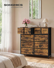 Rustic brown 10 drawer fabric chest in a bedroom with top drawers open beside a mirror and lamp