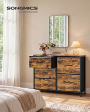 Rustic brown 5 drawer fabric chest in a bedroom with one drawer open beside a mirror and lamp