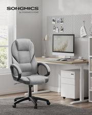 Dove grey executive office chair at a white desk in a bright home office with a monitor