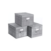 Studio shot of three grey fabric storage boxes with lids and label holders stacked together