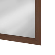 Close-up of the mirror glass edge against the dark brown frame
