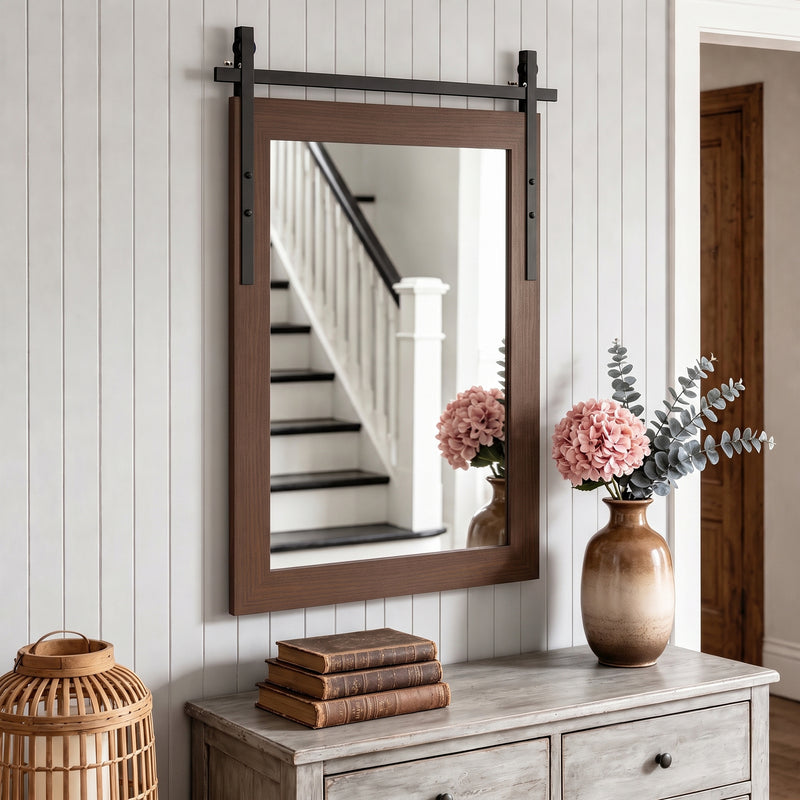 Wall mirror above a hallway chest of drawers beside a staircase