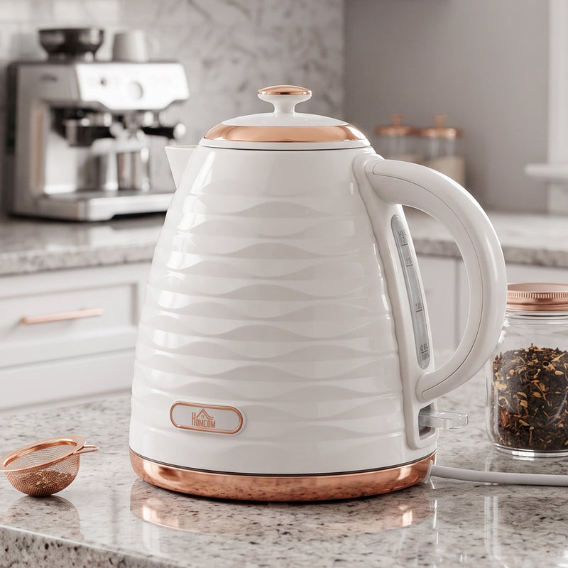 Kettle on a granite worktop with a rose gold tea strainer and loose leaf tea