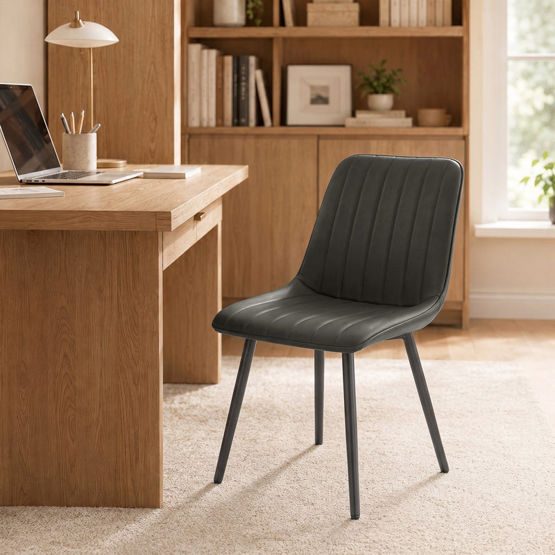 Grey faux leather dining chair used as a home office chair at a wooden desk