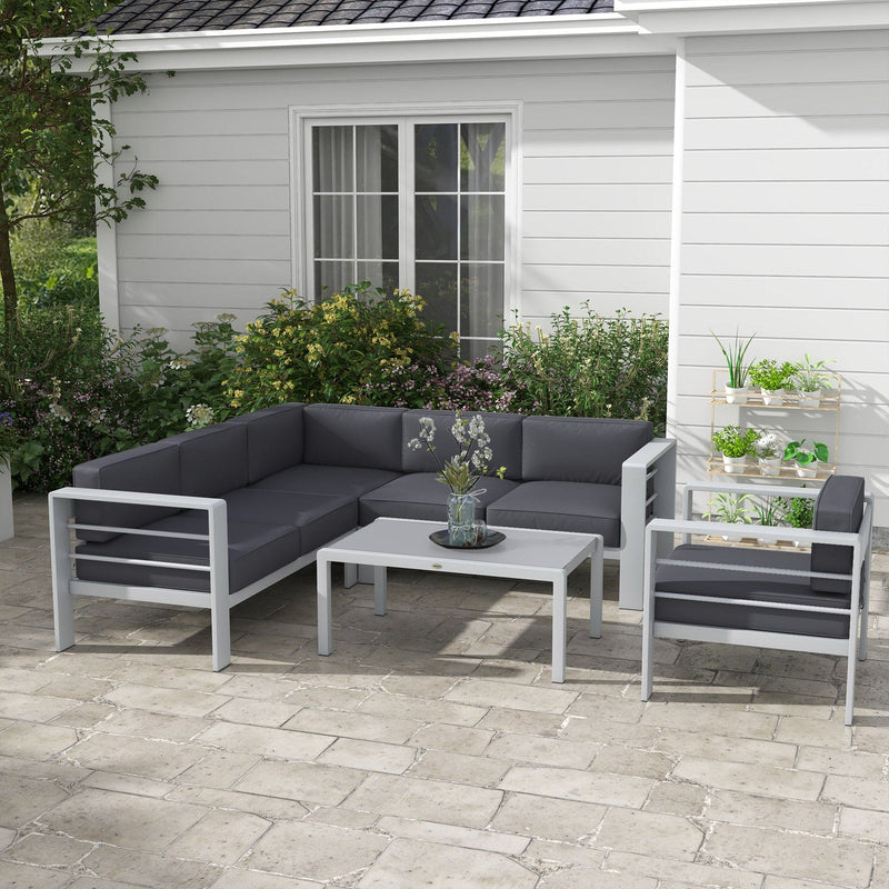 Image of a Grey Outsunny Garden Sofa Set With Table on a patio with some plants and shrubs in the background