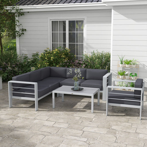 Image of a Grey Outsunny Garden Sofa Set With Table on a patio with some plants and shrubs in the background