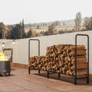 Firewood rack fully stacked with logs on a patio next to a lit fire pit