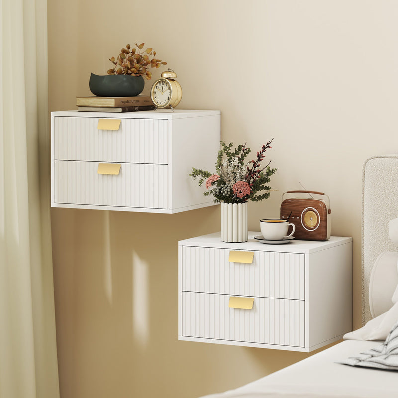 Two white fluted bedside tables wall mounted at different heights in a bedroom