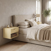 Single oak floating nightstand beside an upholstered bed