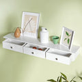 Songmics floating wall shelf with 3 drawers in white, drawers closed