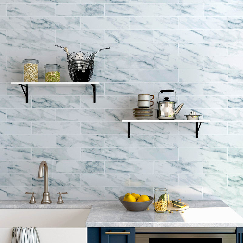 White floating shelves mounted on a kitchen wall holding jars and a kettle