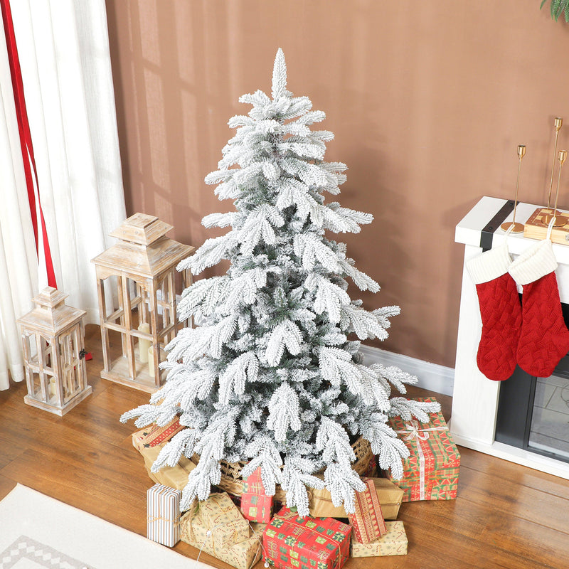 5ft flocked Christmas tree on a brown wall beside a fireplace with red stockings