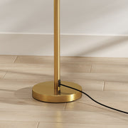 Close-up of the round gold lamp base and black power cord on a wood floor