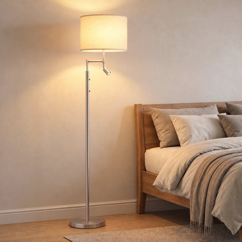 Silver floor lamp glowing beside a bed in a warm bedroom