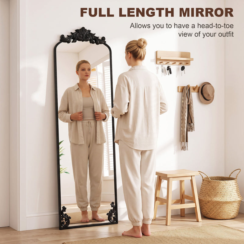 Woman checking her outfit in the full length floor mirror by a hallway coat rack