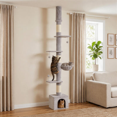 Three cats climbing and resting on the PawHut floor to ceiling cat tree in a living room