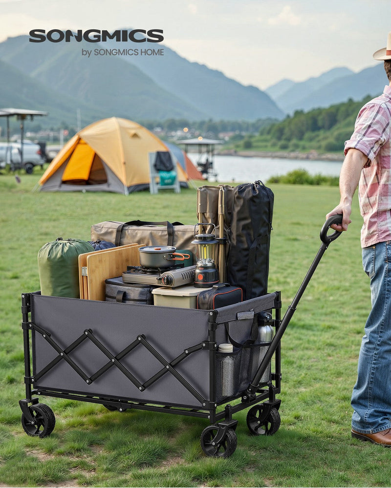 Slate Grey camping cart loaded with camping kit being pulled across grass at a lakeside campsite