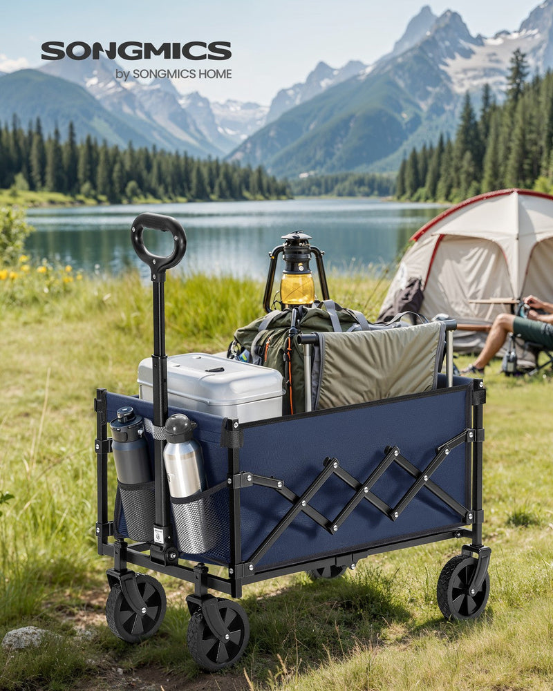 Midnight blue camping cart packed with a cooler and gear beside a lake with a tent in the background