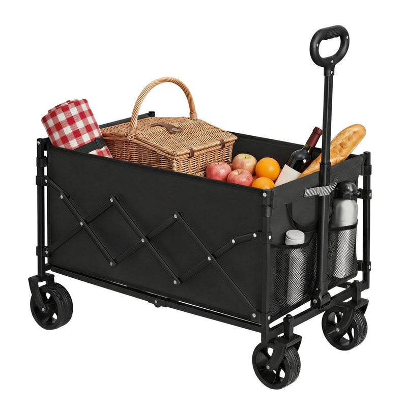 Black camping trolley loaded with a picnic basket, fruit and bread, with bottles in the side pockets