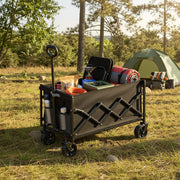 Black trolley loaded with bags and blankets on a woodland campsite among pine trees