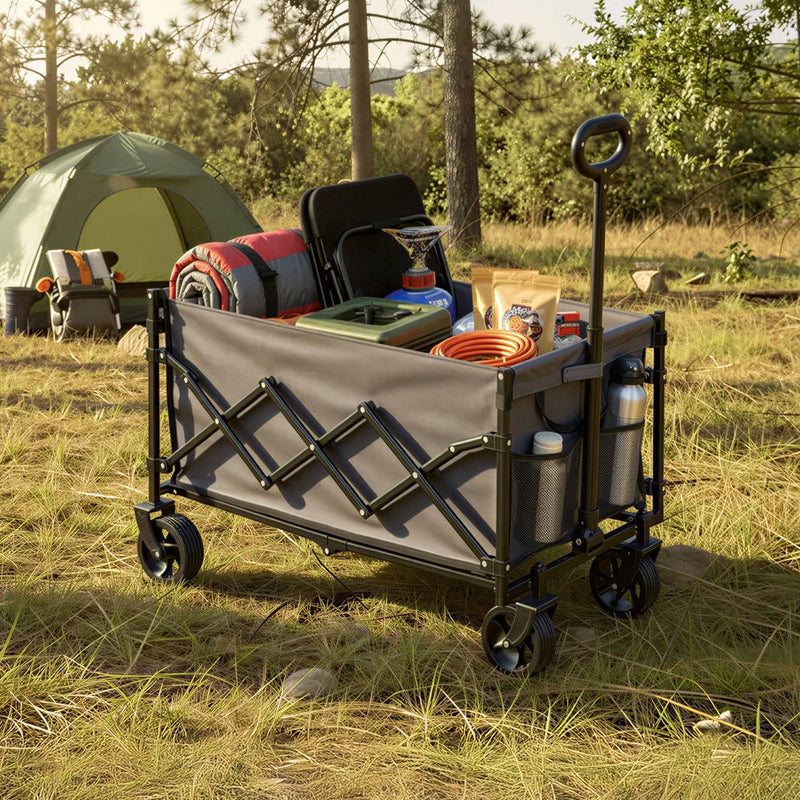 Camping trolley loaded with a cool box, firewood and camp chairs among trees at a campsite