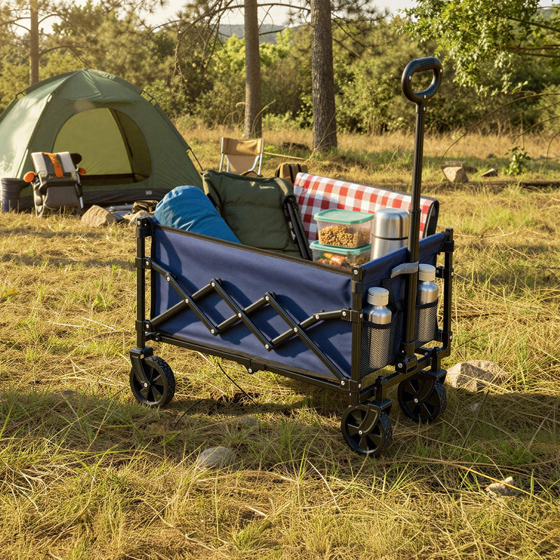 Blue trolley carrying a sleeping bag and camping chair beside a green tent at a woodland campsite