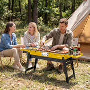 Yellow Outsunny BBQ grill in use at a campsite with friends grilling sausages