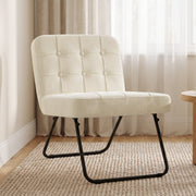 Cream white foldable accent chair beside a window on a woven rug