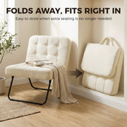 Cream white accent chair open beside a window and folded flat against the wall