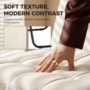 Hand pressing the tufted cream white chenille seat beside a black metal frame detail