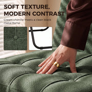 Hand pressing the tufted light green chenille seat beside a black metal frame detail