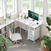 White foldable desk with a monitor and keyboard in a bright room by a window with a white chair