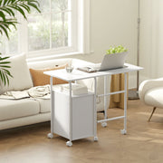 White foldable desk opened as a laptop table beside a sofa under a window