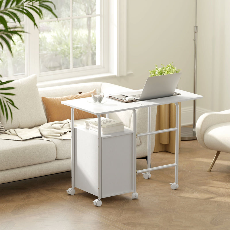 White foldable desk opened as a laptop table beside a sofa under a window