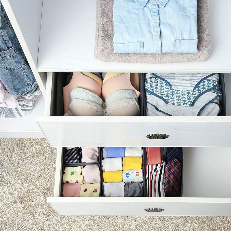 Grey fabric organisers inside two open white drawers holding underwear and socks
